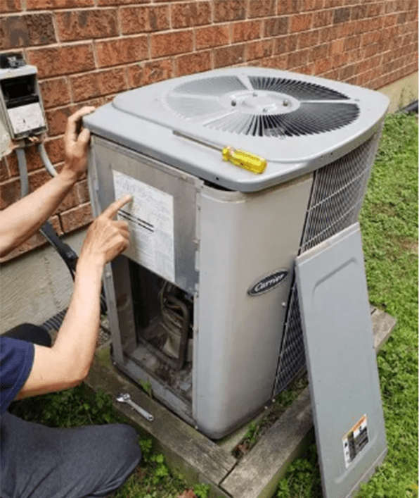 a man is disassembling the air conditioner outdoor unit and reading the instruction on it